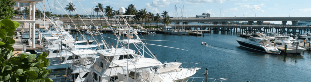 A marina with high-value boats docked near a commercial area. Marine dealerships are prime targets for theft, making AI-powered surveillance essential for securing valuable assets and preventing unauthorized access.